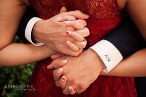 clasped hands and red dress with hearts on nails and dress shirt initials