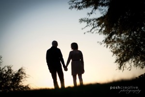 silhouette couple look at each other holding hands watching sunset